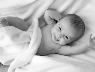 Lachendes Baby auf Decke