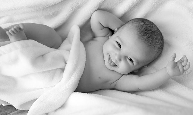 Lachendes Baby auf Decke
